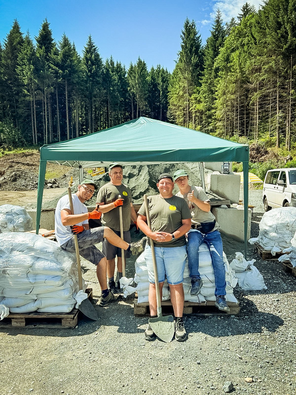 Arbeitseinsatz im Freien, die Gruppe macht Pause unter einem Pavillon