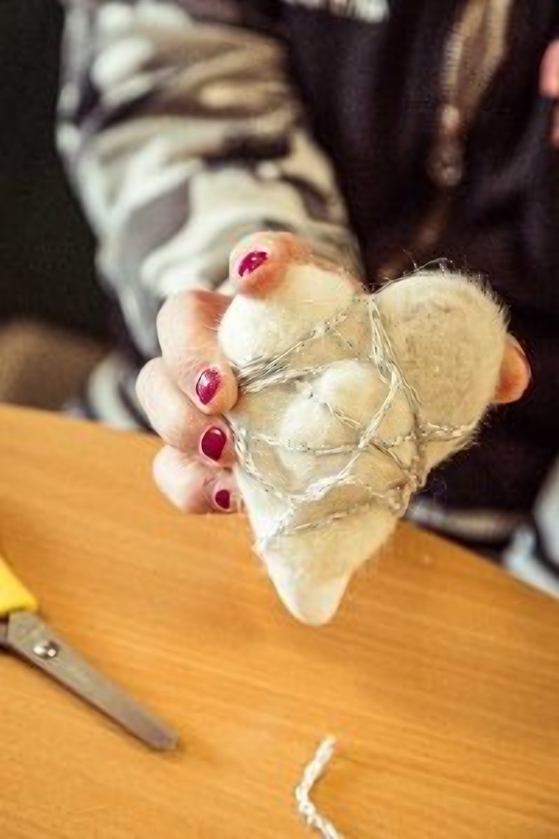 Hände halten ein selbst gefilztes Herz