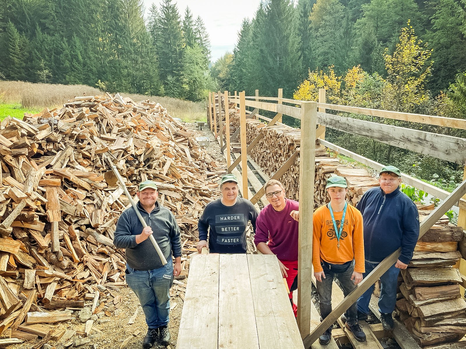 Eine Gruppe arbeitet gemeinsam an einem großen Holzstoß