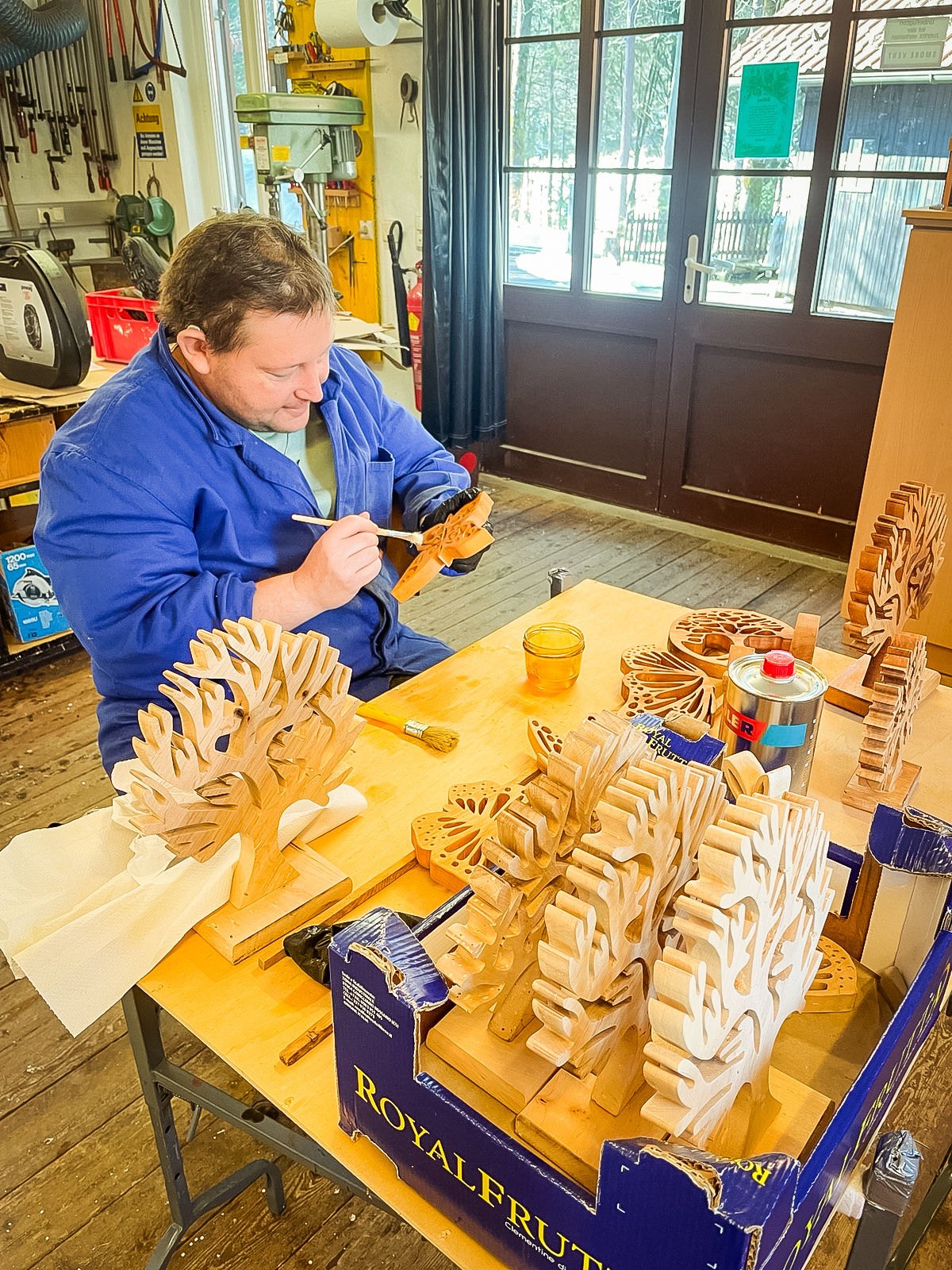 Ein Mitarbeiter arbeitet an Holzwerkstücken in der Werkstatt