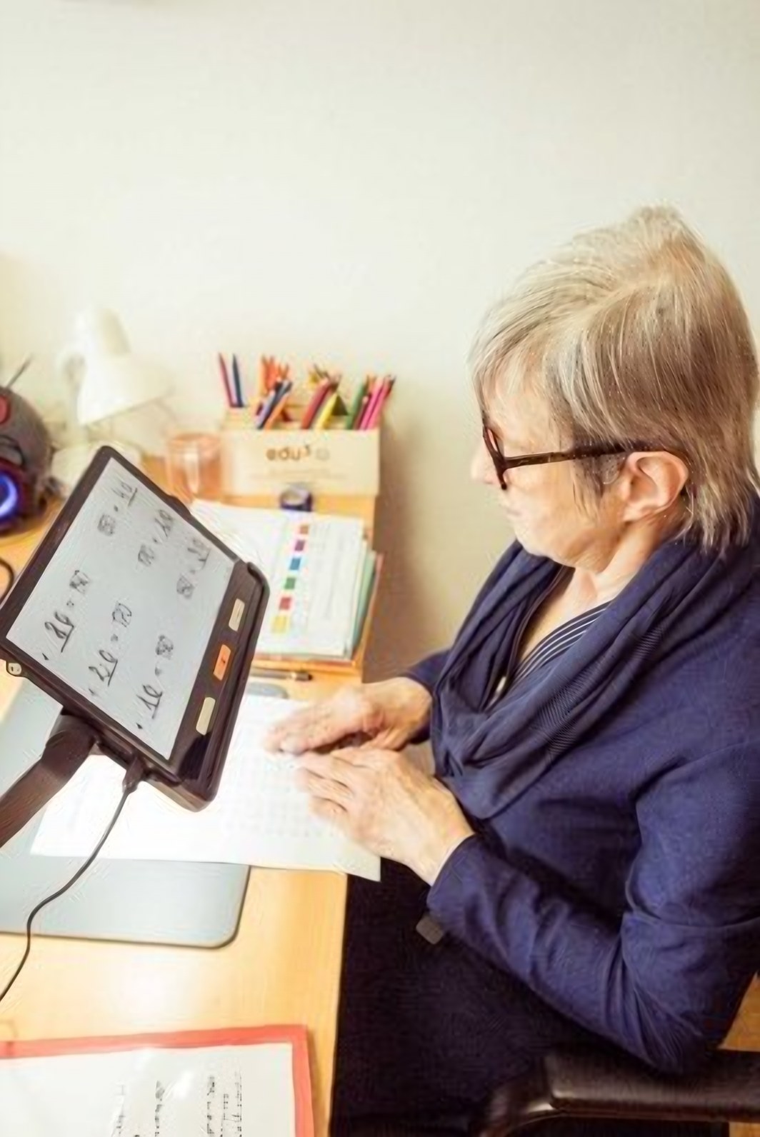 Eine Frau arbeitet am Tablet an ihrem Schreibtisch