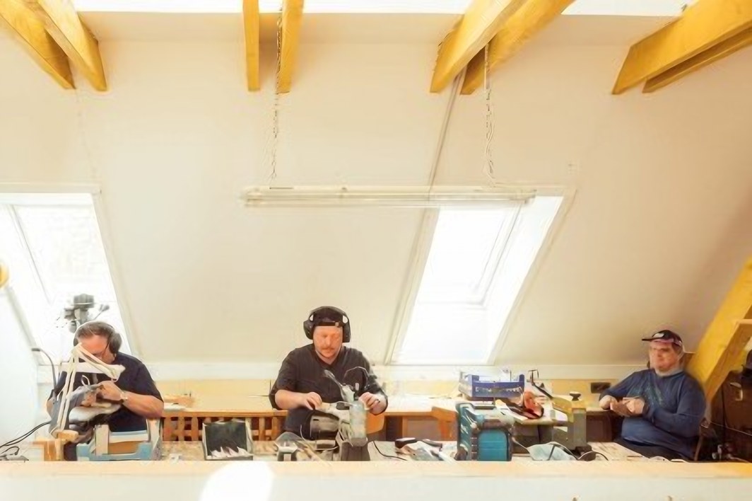Mehrere Personen arbeiten an Tischen im hellen Werkraum