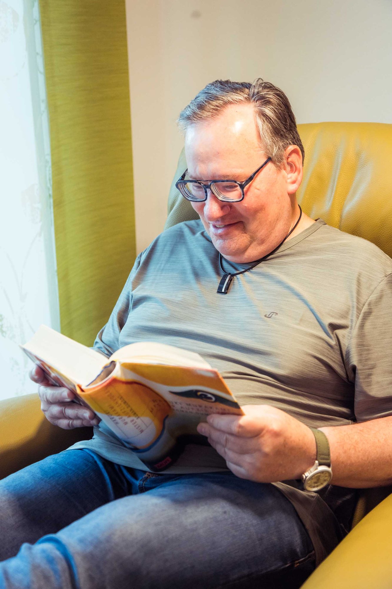 Ein Bewohner liest entspannt in einem Buch